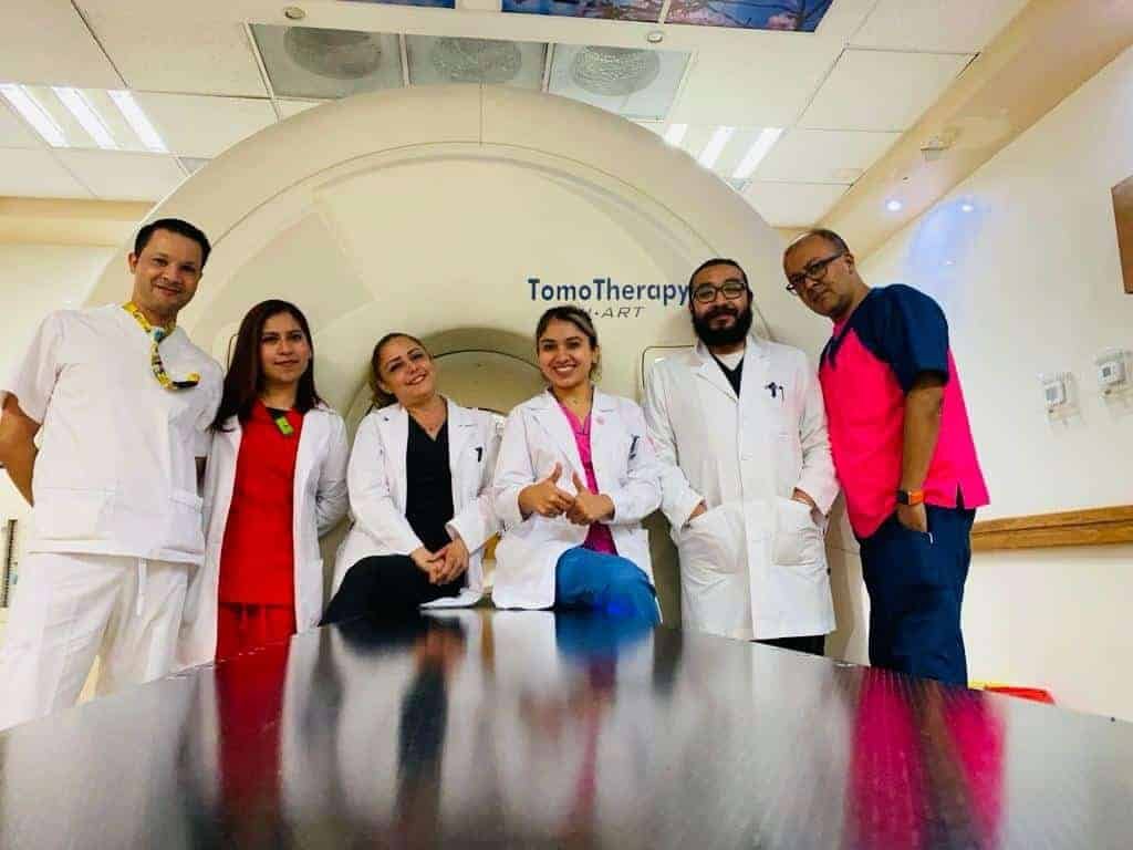 Equipo médico de especialistas en radioterapia en CDMX frente a máquina TomoTherapy, listos para tratamientos oncológicos de alta precisión.